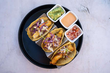 Top down view of delicious fish tacos with guacamole and salsa,, white background, no people ,copy spaceの写真素材