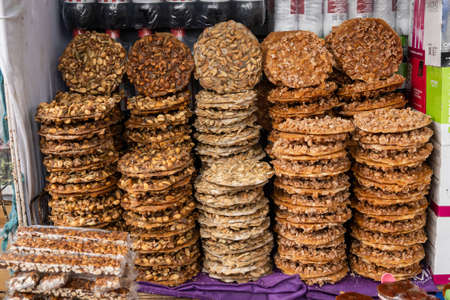 Mexican sweet snack (palanquetas) with peanuts, seeds and honey, display at market, piles ofの写真素材