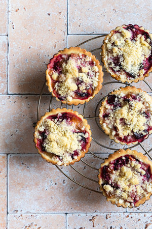 Two home baked plum crumble tarts with a forkの写真素材