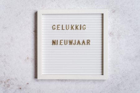A white letterboard with the text in golden letters spelling Happy New Year (Dutch for Happy New Year)の写真素材