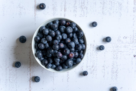 Top down view of a bowl of fresh blueberries on white background, horizontal, copyspace