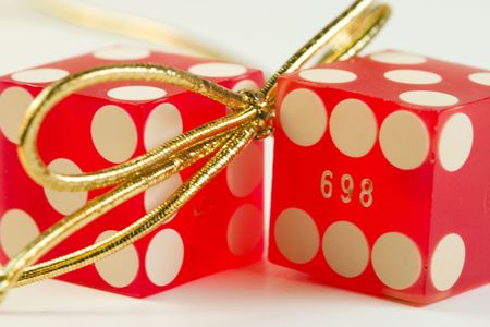 two red dice and a gold ribbon tie