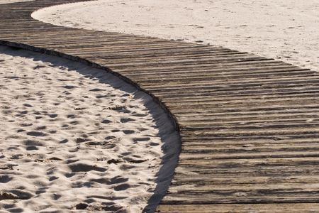 Jogging path lined with old wooden planks on the sandの写真素材