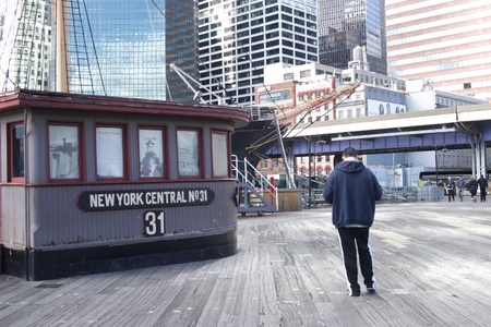 Man waiting by the ticket kiosk at NYC's South Street Seaport waterfront のeditorial素材