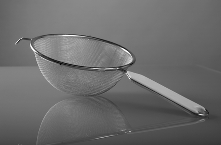 Metallic strainer with plastic handle, a modern kitchen utensilの写真素材