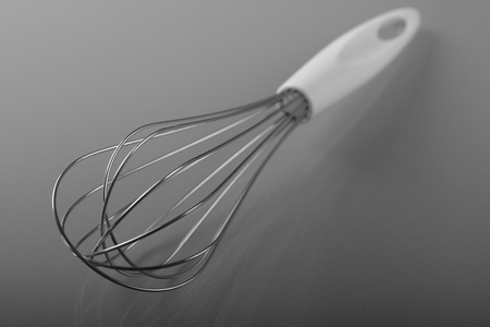 Close up of hand mixer for stirring cake, eggbeater, whisk on blurred gray backgroundの写真素材