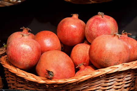 Pomegranates in a straw basket at the Marketの写真素材