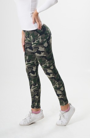 Girl in camouflage leggings, white blouse and white sneakers