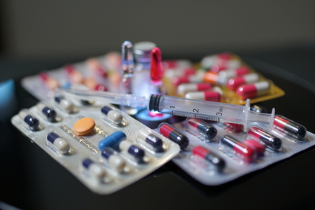 Pills and drugs. Medicine, capsules in blister, tablets, injection, syringe and needle. Close-up of...