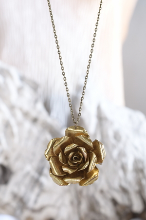 Vintage brass jewelry necklace in the form of a flower on the stone background, hand madeの写真素材