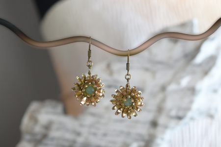 Vintage brass earrings in the form of a flower on the white stone, hand madeの写真素材