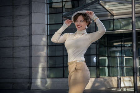 Outdoor fashion portrait of young beautiful fashionable girl with beret, posing in European city,...