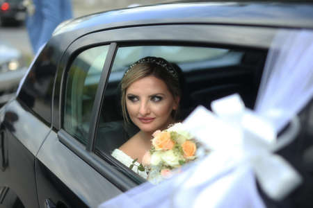 Photo of bride in car enjoy moment of happiness. Portrait of happy bride looks out of the car windowの写真素材
