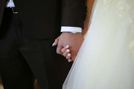 Wedding theme, holding hands newlyweds. The bride and groom hold each other's hands. Loving coupleの写真素材