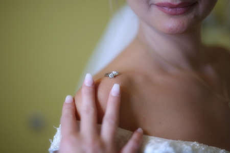 A elegant and beautiful bride at home. Beauty portrait of bride wearing fashion wedding dress with luxury delight make-up and hairstyleの写真素材