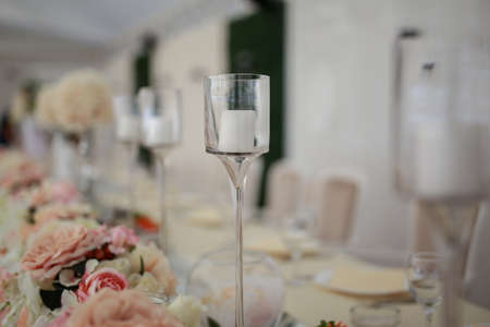 Festive table set with candles and flowers bouquet. Wedding concept. Fine dining wedding reception cateringの写真素材