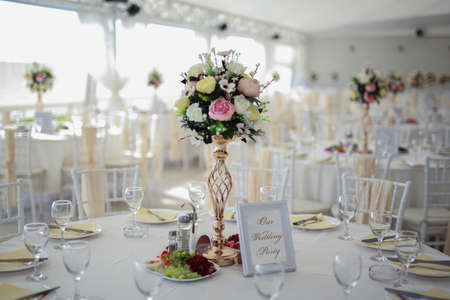 Chairs and table decorated with flowers, served with cutlery and crockery and covered with a tablecloth. Special wedding conceptの写真素材