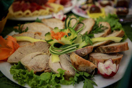 Roast pork loin with cucumber and radish salad. Grilled pork neck served with sliced ??cucumber, grilled pork on a white plateの写真素材