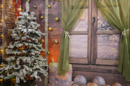 Wooden window with green curtains and christmas balls and candles. Christmas tree with cones. Christmas photo zoneの写真素材
