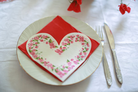 Decorated straw plate in the shape of a heart with cutlery for wedding and other kinds of festivitiesの写真素材