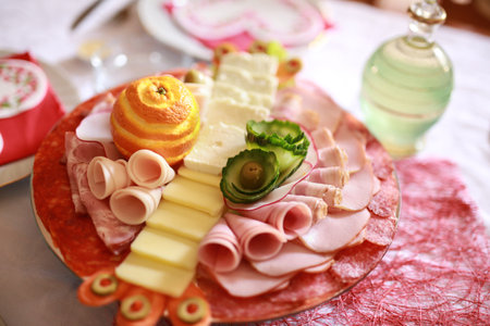 Food tray with delicious salami, pieces of sliced ham, sausage and yellow cheeseの写真素材