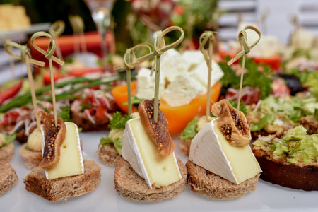 Food tray with delicious and different cheese with delicious salami, pieces of sliced ham, sausageの写真素材