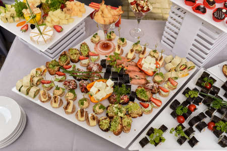 Food tray with delicious and different cheese with delicious salami, pieces of sliced ham, sausageの写真素材