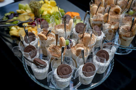 Small sweet treats turned into cakes enriched with chocolate, waffles, biscuits and fruitの写真素材
