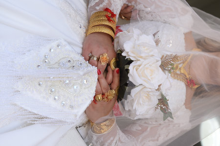 Gold jewelry and roses on the hands of a Muslim brideの写真素材