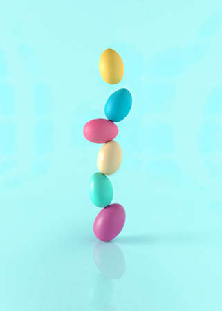 Colorful concept of creative standing Easter eggs on pastel blue background.