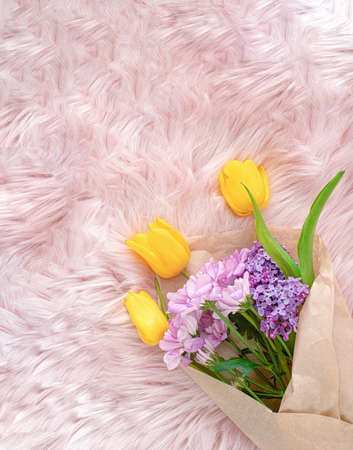 Vintage, alternative bouquet of fresh Spring flowers on a fluffy, soft pastel pink background....