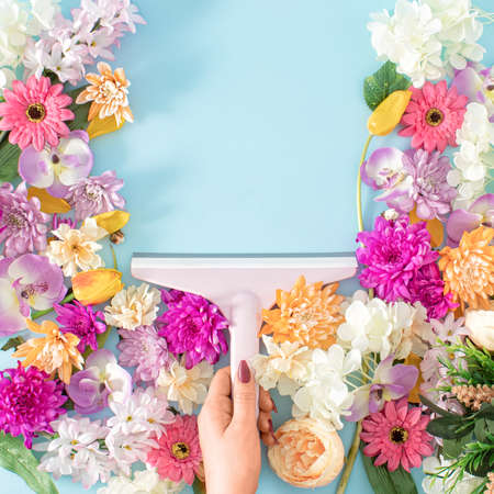 Creative concept of plastic windshield wiper which removes fresh Spring flowersand leaves a pastel...