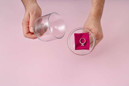 Engagement creative concept of proposal with big diamond ring. Pastel pink background. Will you...