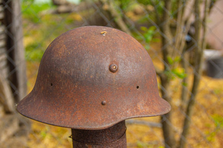 Old rusty steel helmet in the garden, closeup of photo.の写真素材