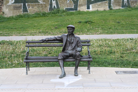 Sculpture of a man sitting on a bench in the parkの写真素材