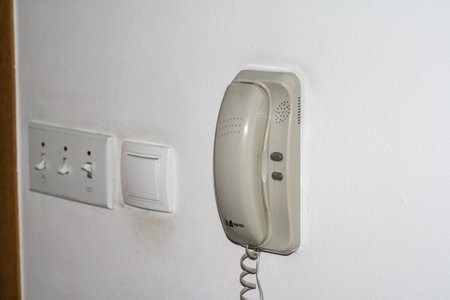 Close up of a telephone receiver on a white wall in a room