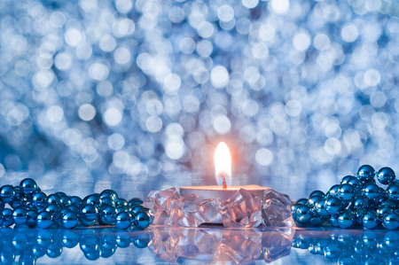 Flame of candle and Christmas decorations on the background bokehの写真素材
