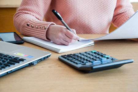 A woman conducts accounting calculations in the officeの写真素材