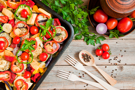 Fresh organic vegetables cut in pieces, prepared for baking on the dish for bakingの写真素材