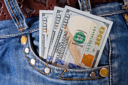 Dollar banknotes in the pocket of jeans