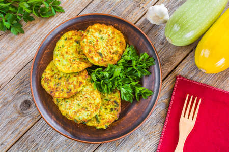 Zucchini pancakes with parsley on a wooden tableの写真素材