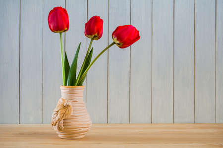 Beautiful bouquet of red tulips in a vase on the table. Still lifeの写真素材
