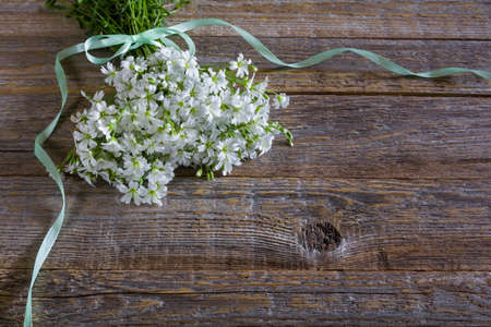 Bouquet of white wildflowers of stellaria holostea on a wooden background