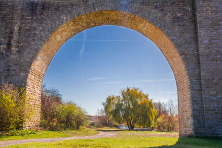 View through the arch of the stone bridge-viaduct. S. Ostriv, Ternopil region, Ukraineの写真素材