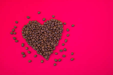 Heart shaped coffee beans on a crimson background