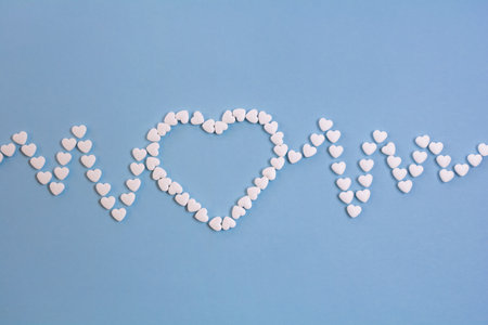 Heartbeat line and heart made of heart shaped pills. cardiogram line