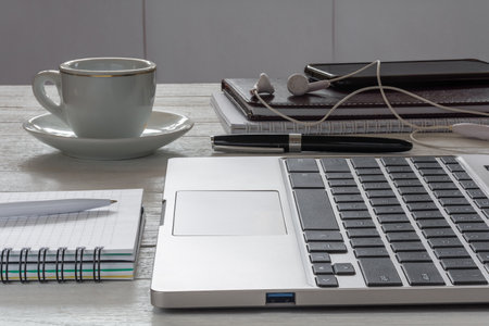 workplace. A laptop, a cup of coffee and other accessories on a white desktop. side viewの写真素材