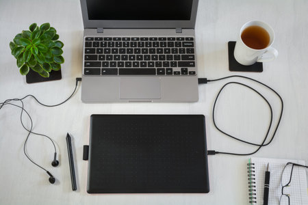 Graphic designer workplace: laptop with graphic tablet on white desktopの写真素材
