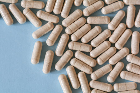 Medicines in transparent capsules with brown powder on a blue backgroundの写真素材