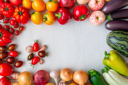 Flat lay of vegetables and fruits arranged as frame on white wooden tableの写真素材